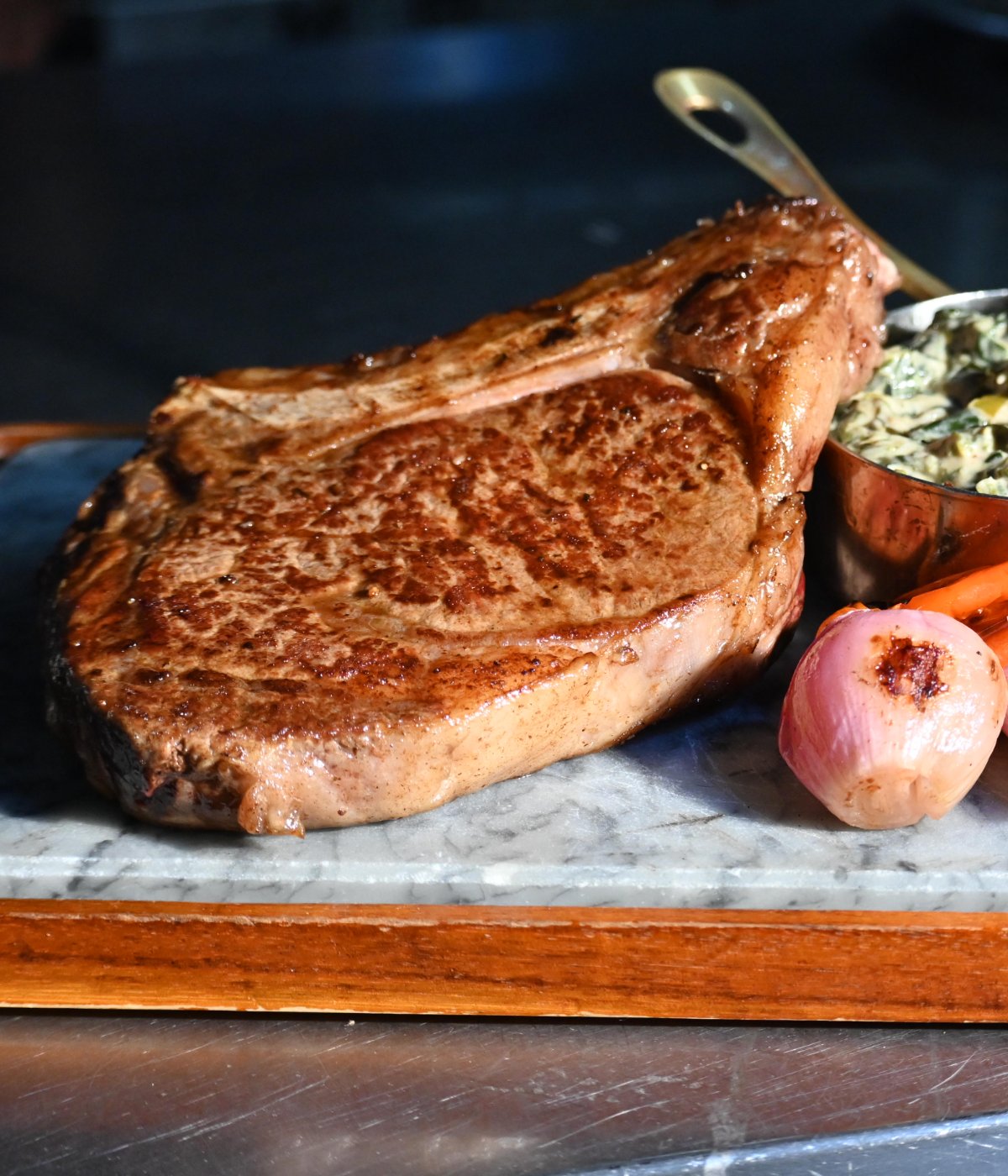 Bone-in ribeye on marble with creamed spinach and charred shallots at The Stone House at Clove Lakes